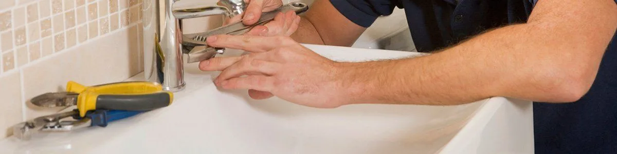 Plumbing tools beside a tap